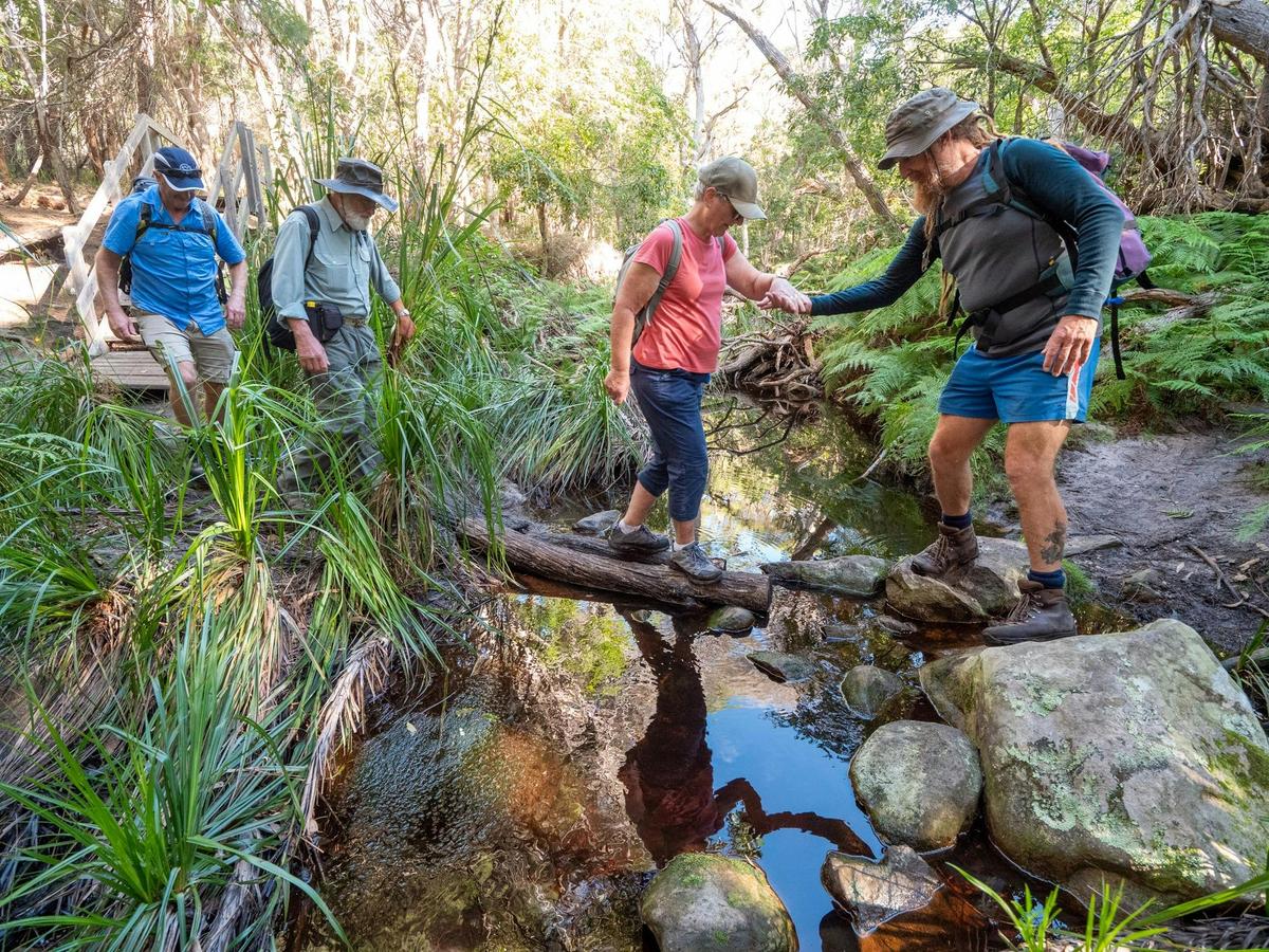Guest being guided over a stream