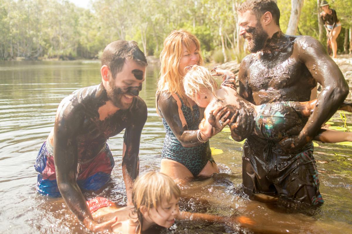 A family & a Localing host enjoy playing in the mud.