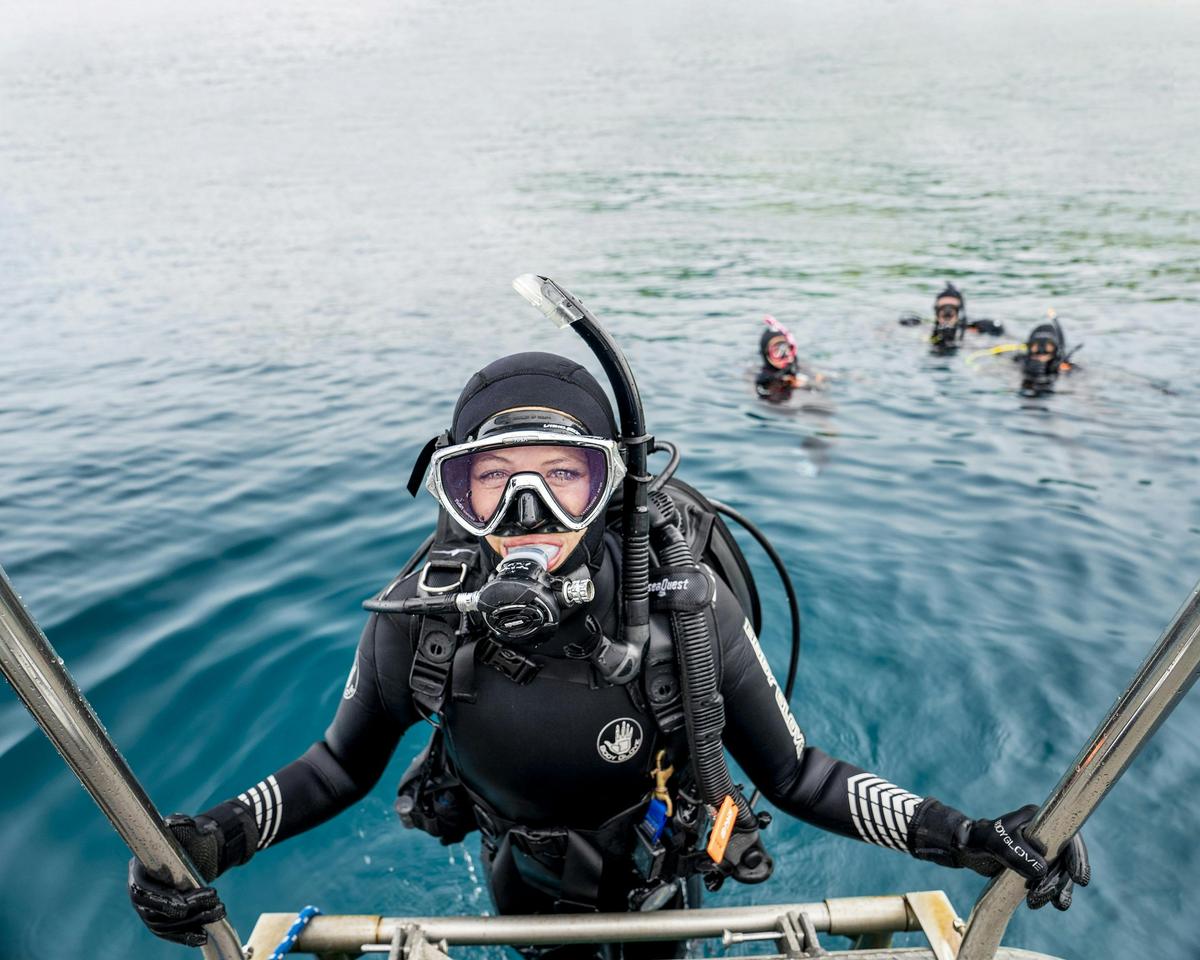 Diver exits water onto boat using a ladder