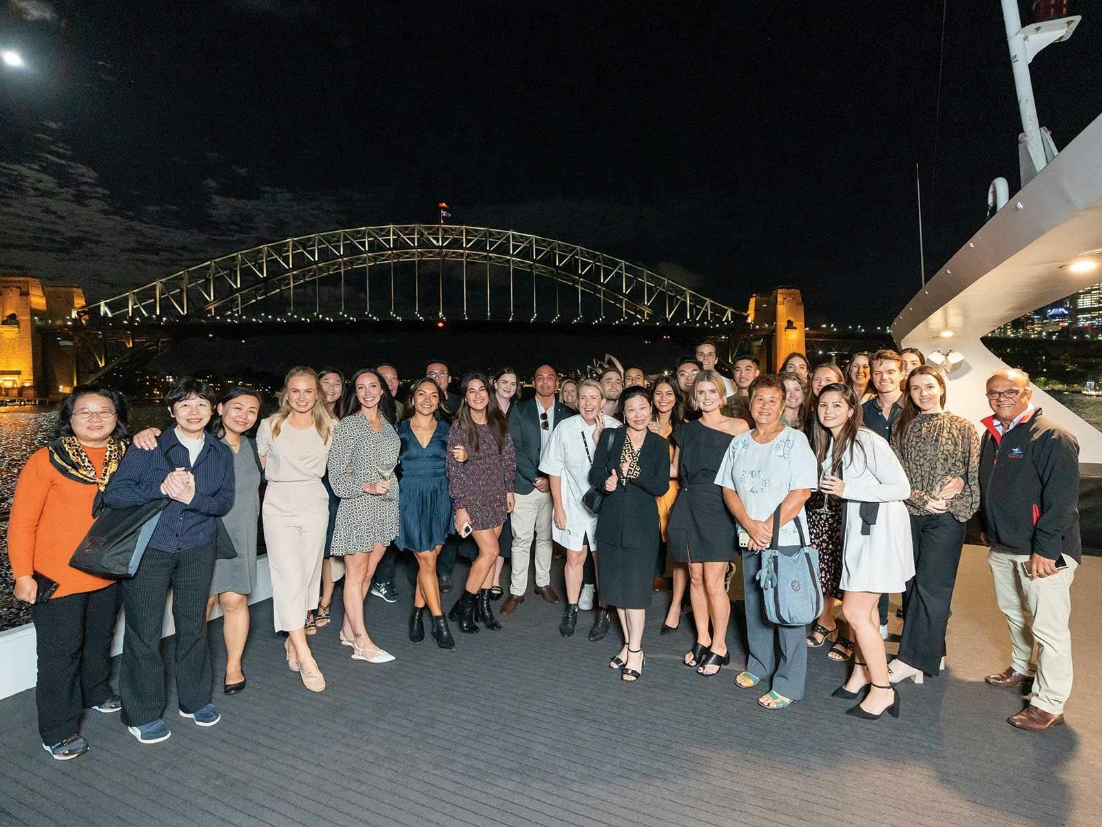 Guests pose for a picture with the Harbour Bridge in the background