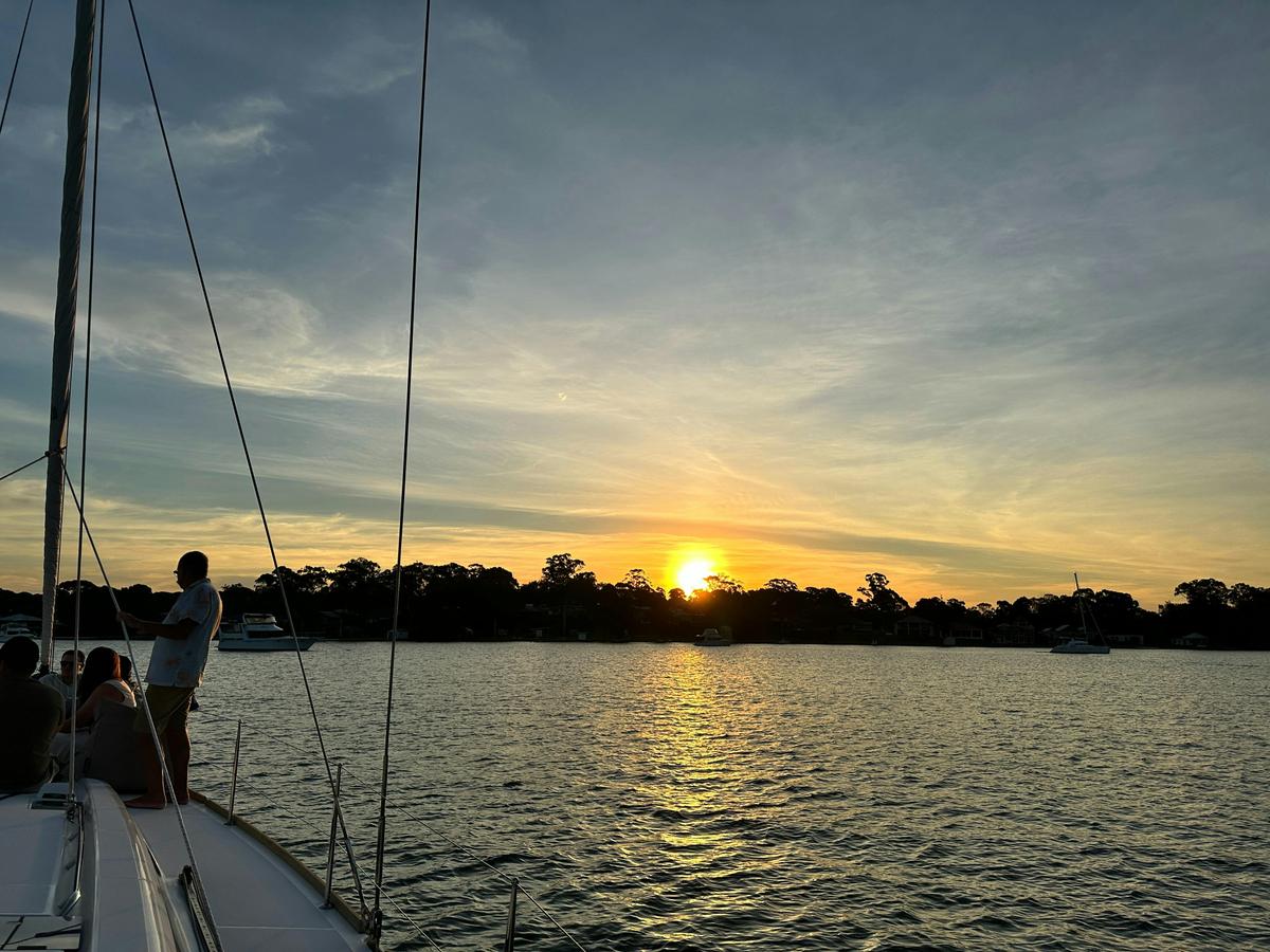 Guests enjoying the sunset on the bow of Sail Lake Macquarie's yacht MR