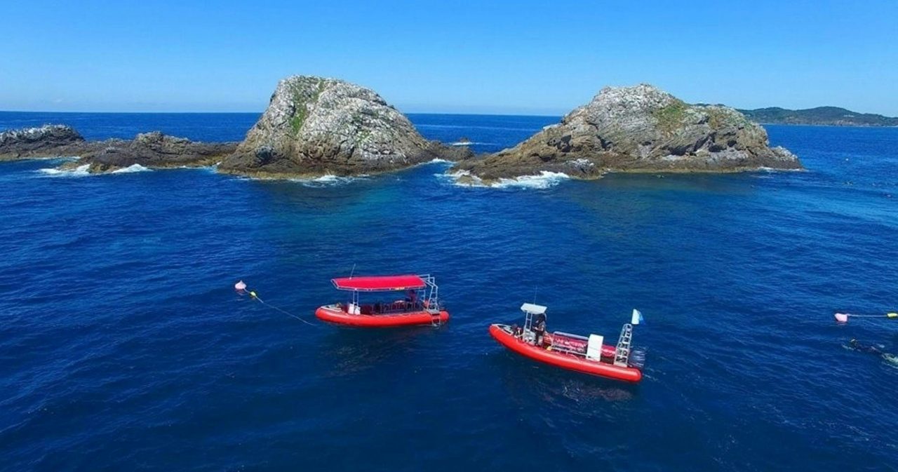 Two red boats in front of Nguthungulli Julian Rocks