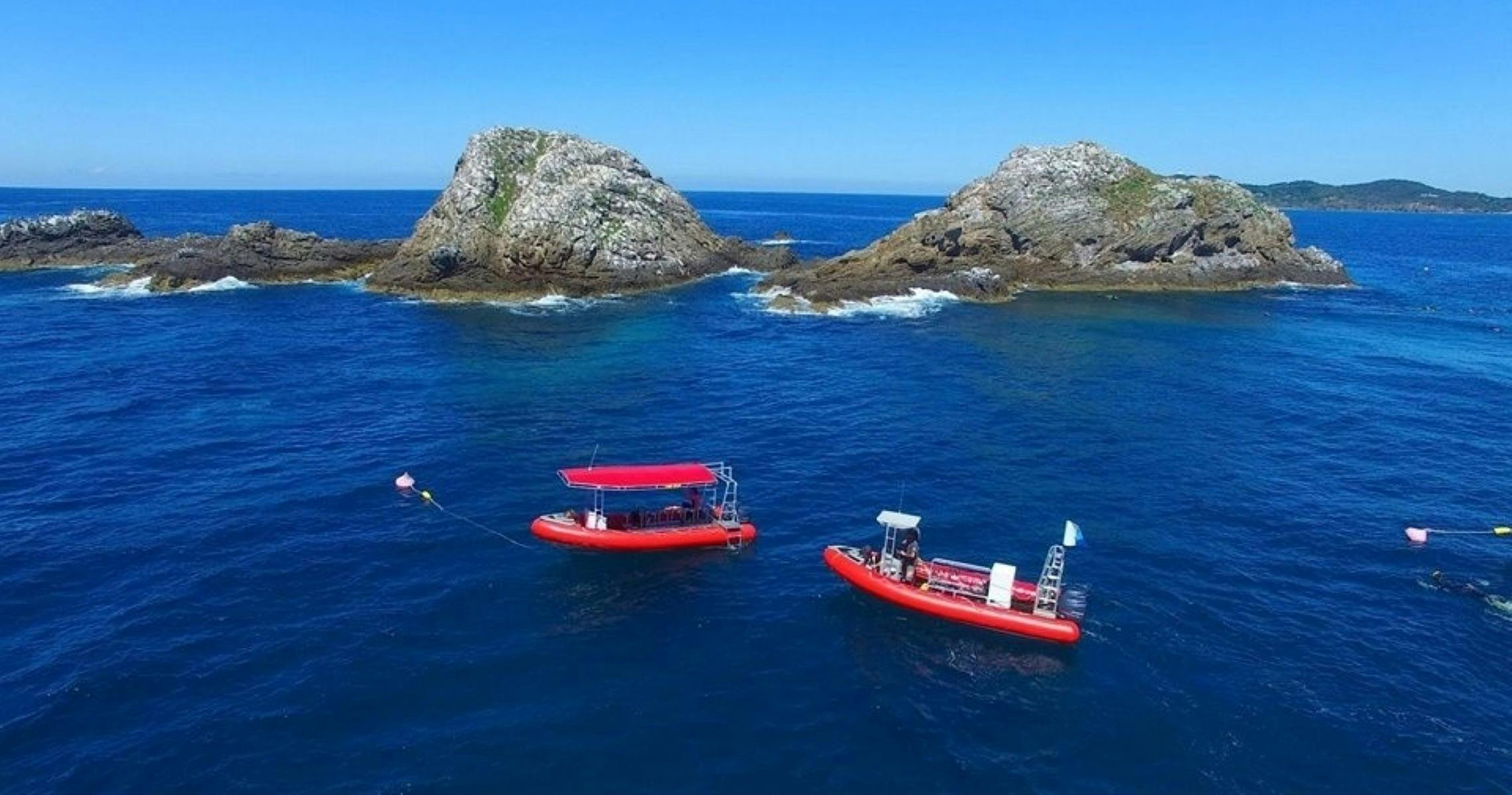 Two red boats in front of Nguthungulli Julian Rocks