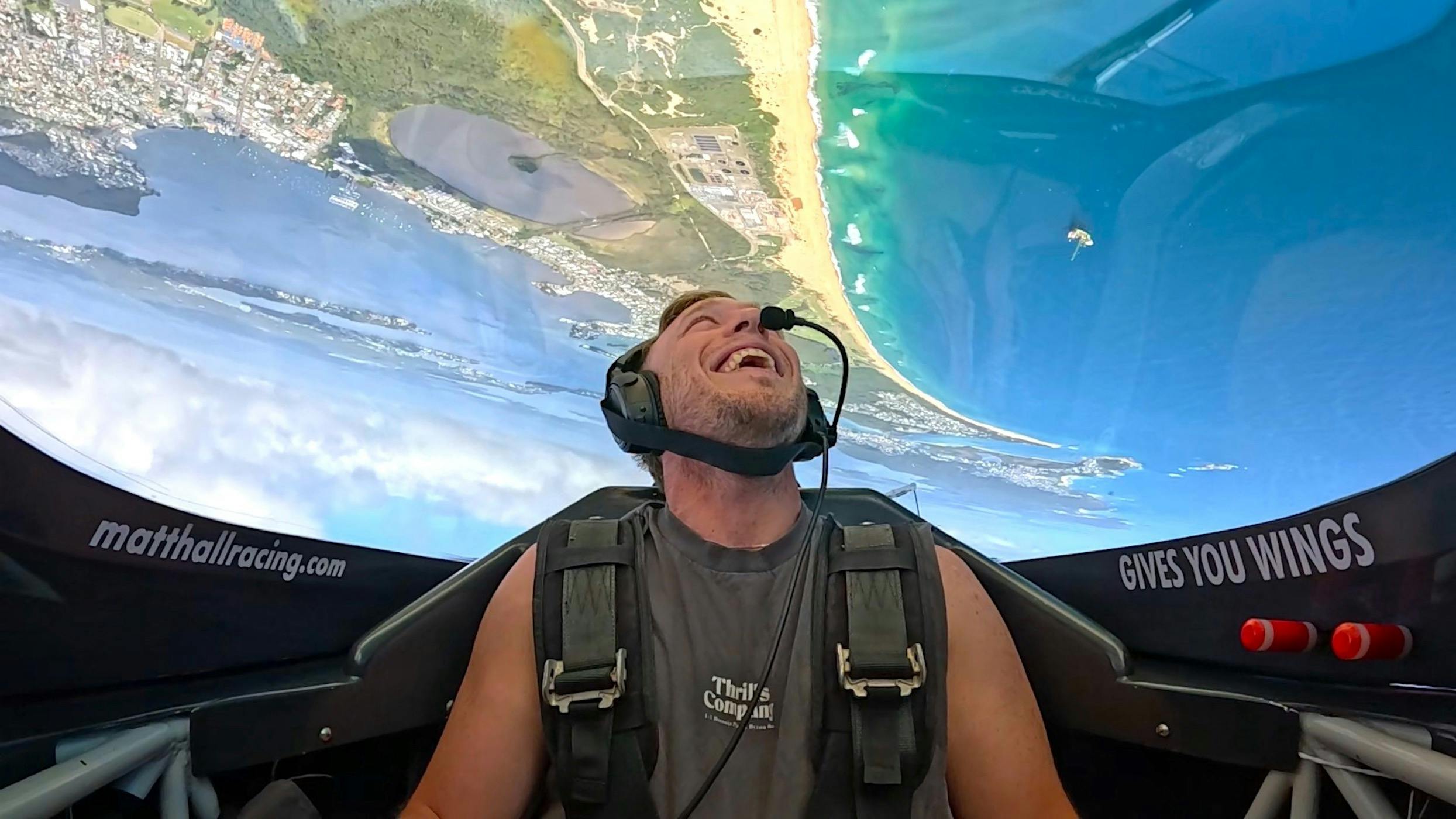 Aerobatic joy flight passenger strapped in for the ultimate experience overhead Lake Macquarie, NSW