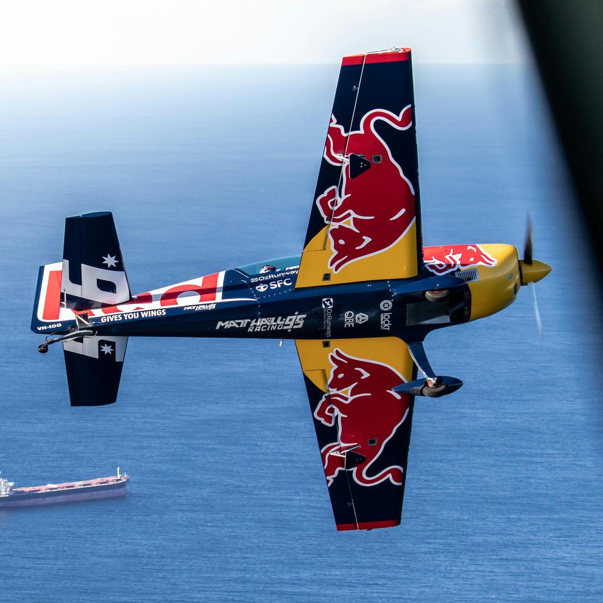 Matt Hall Racing Aerobatic Aeroplane Red Bull, flying over Newcastle Beaches, Lake Macquarie NSW