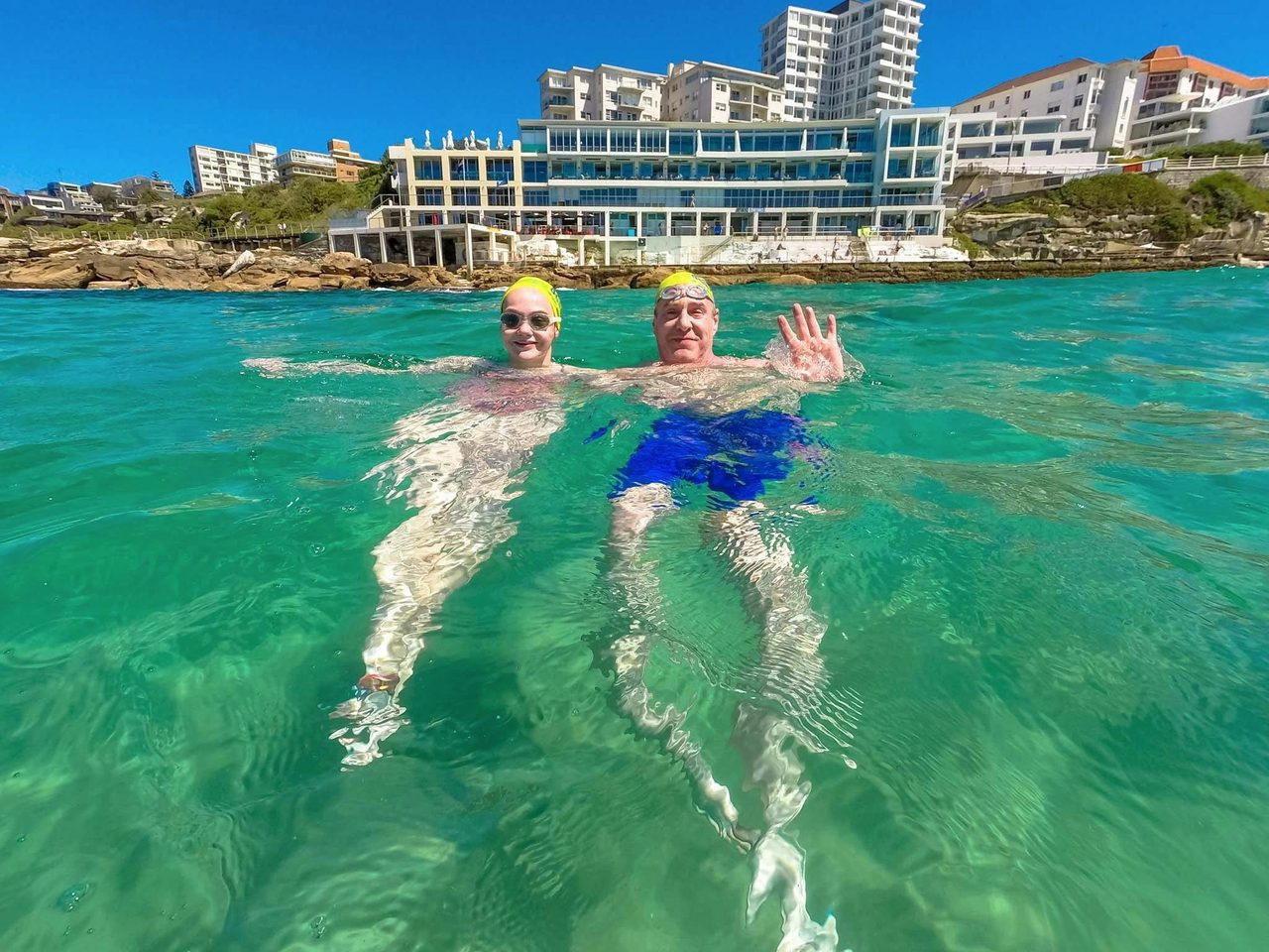 A father and daughter from the USA enjoy a moment in front of Icebergs after swimming across Bondi.