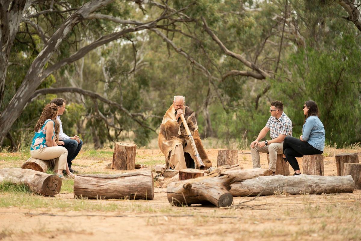 Two young couples enjoying a live didgeridoo music performance
