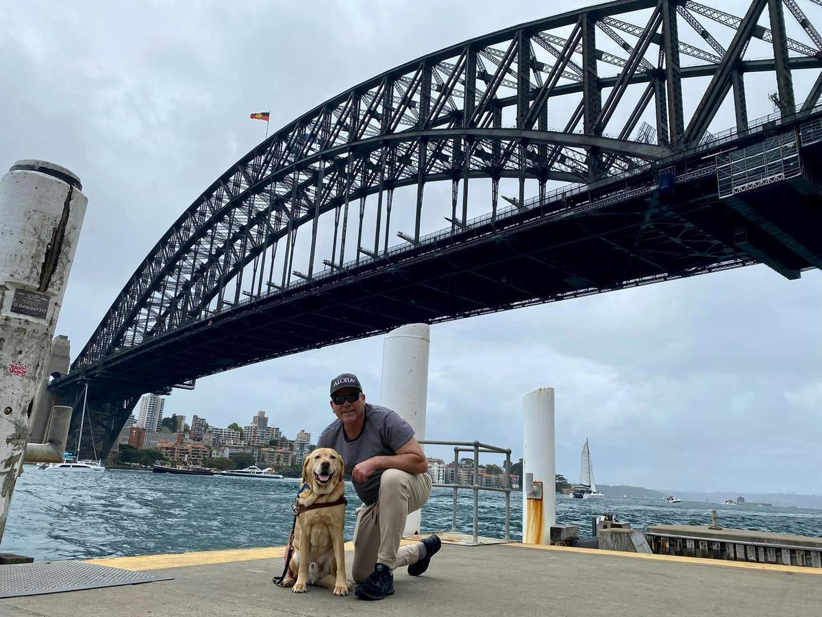 traveller and his Guide Dog pictured infront of the Sydney Harbour Bridge