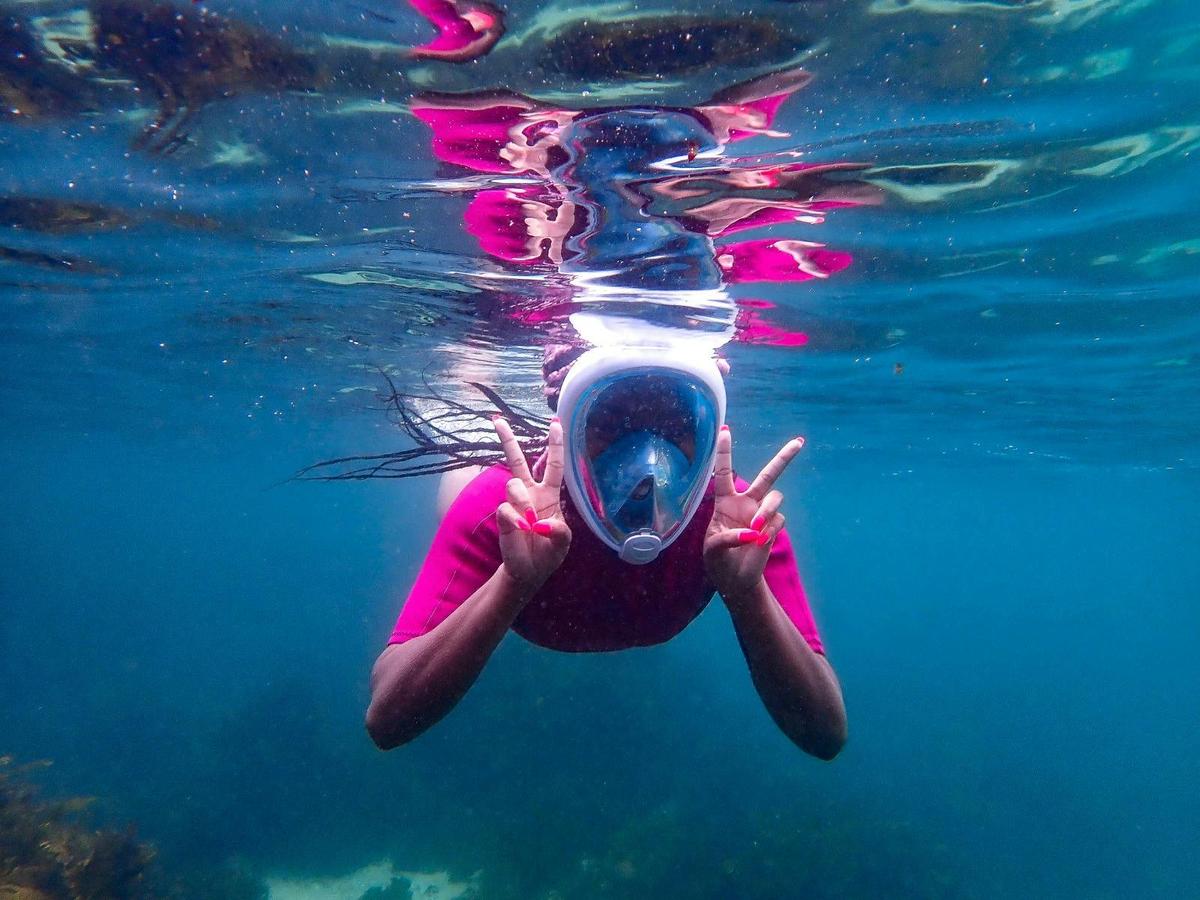 Happy snorkeller in the water wearing a full face snorkeling mask