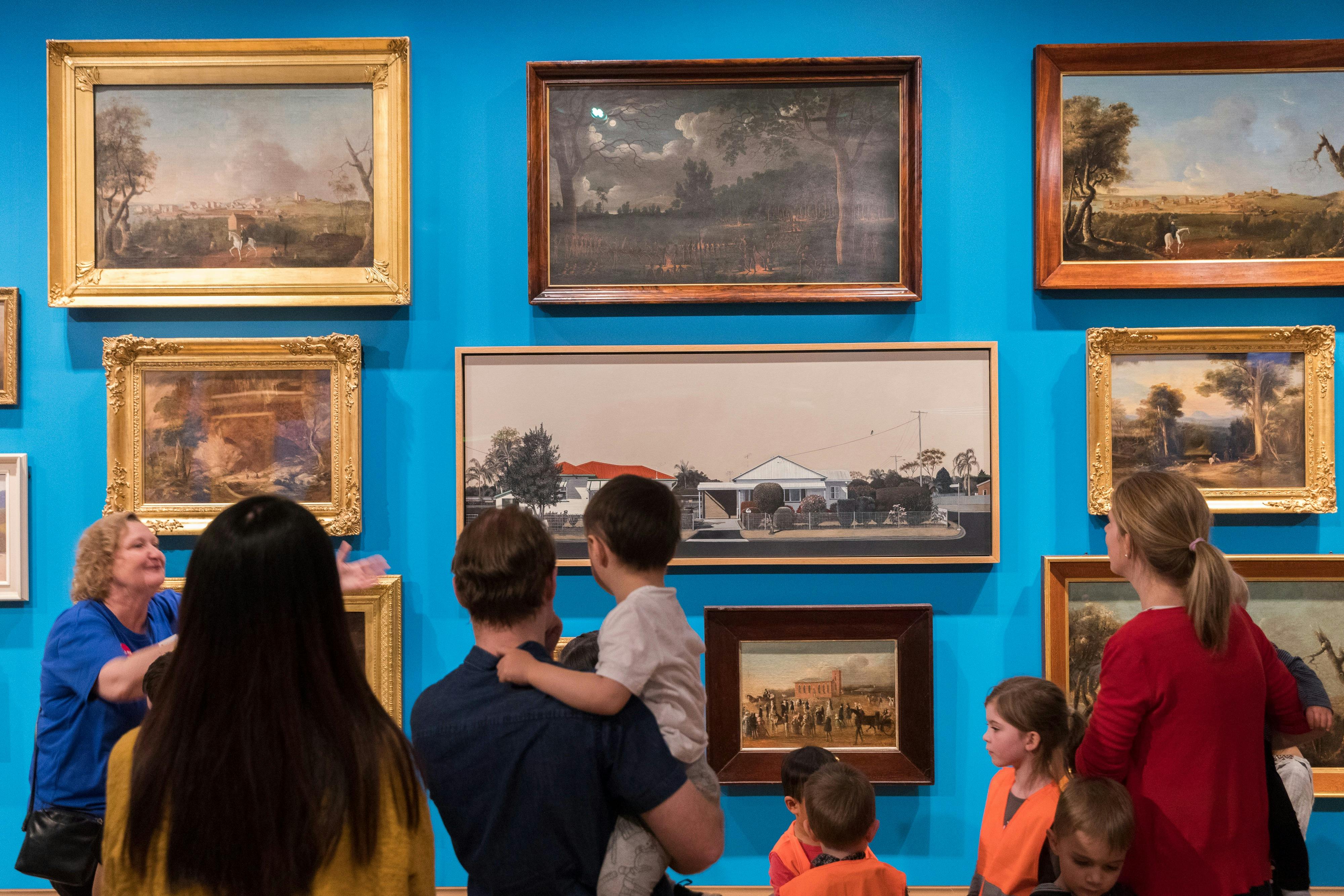 Parents and children looking at art in a gallery.