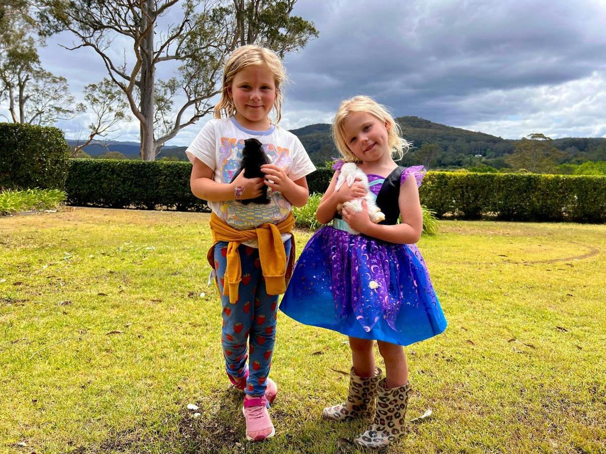 Two young girls enjoying time with adorable bunnies