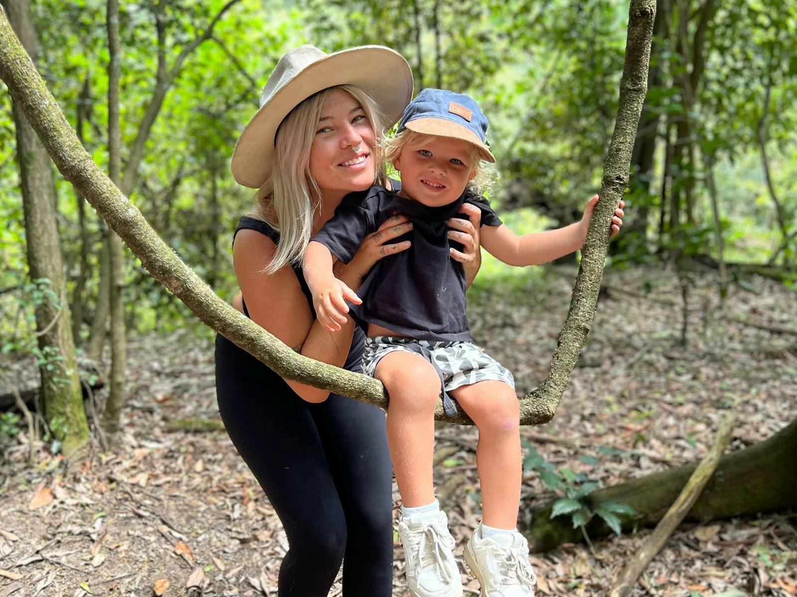 Mum and son smiling together while exploring nature on a farm tour