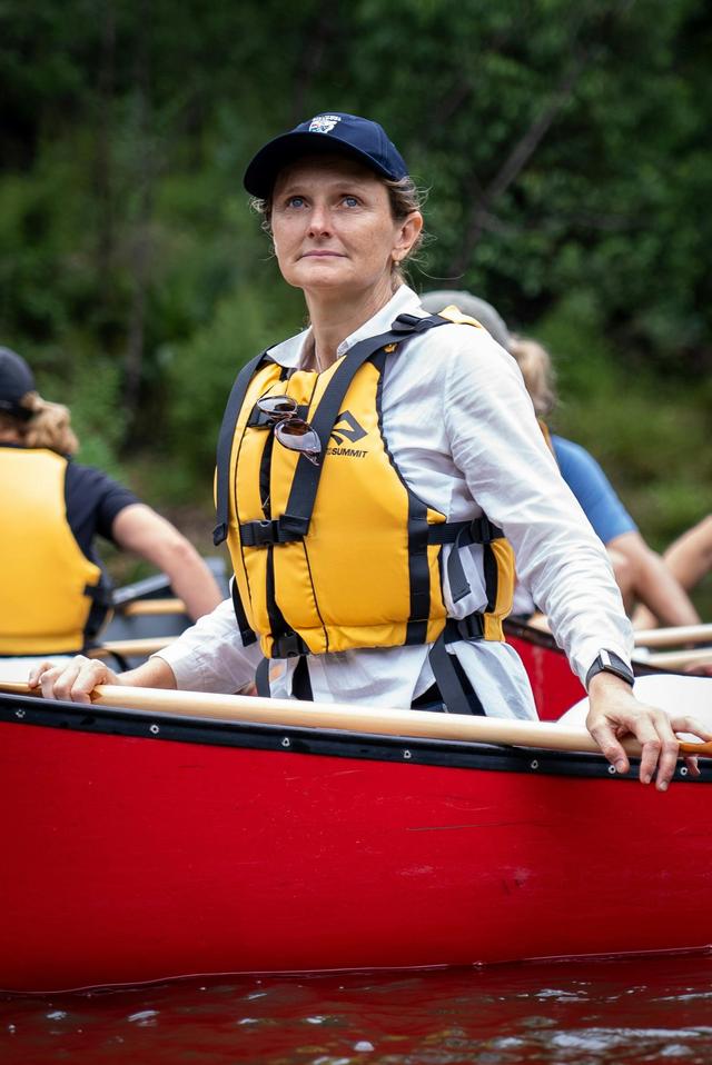 A woman in a red canoe wearing a yellow lifejacket
