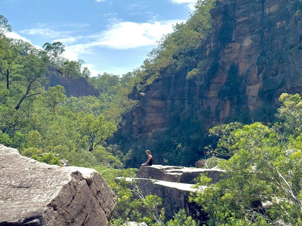 A  man sits on a rock overlooking the gorge
