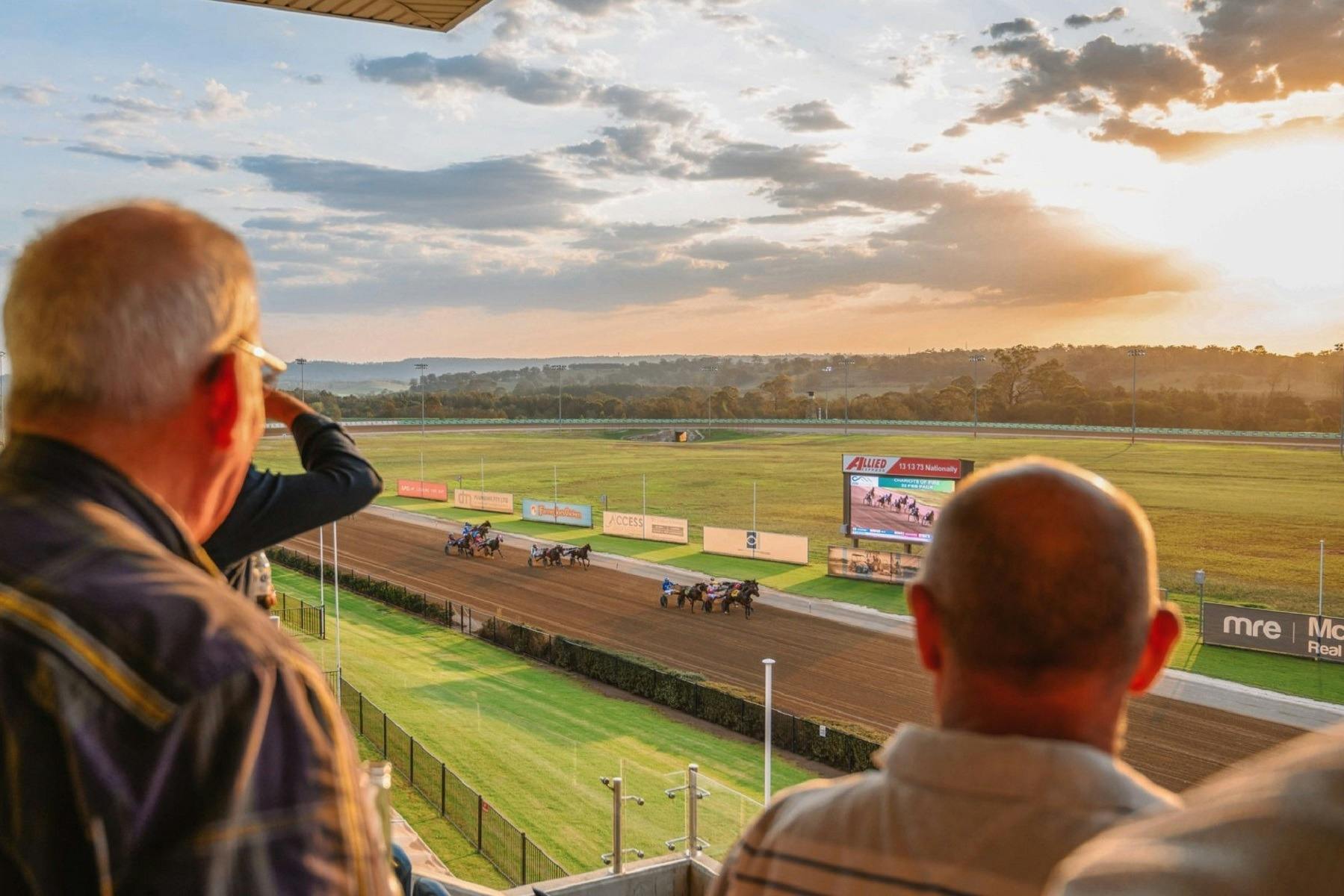 People watching harness race from grandstand at Club Menangle