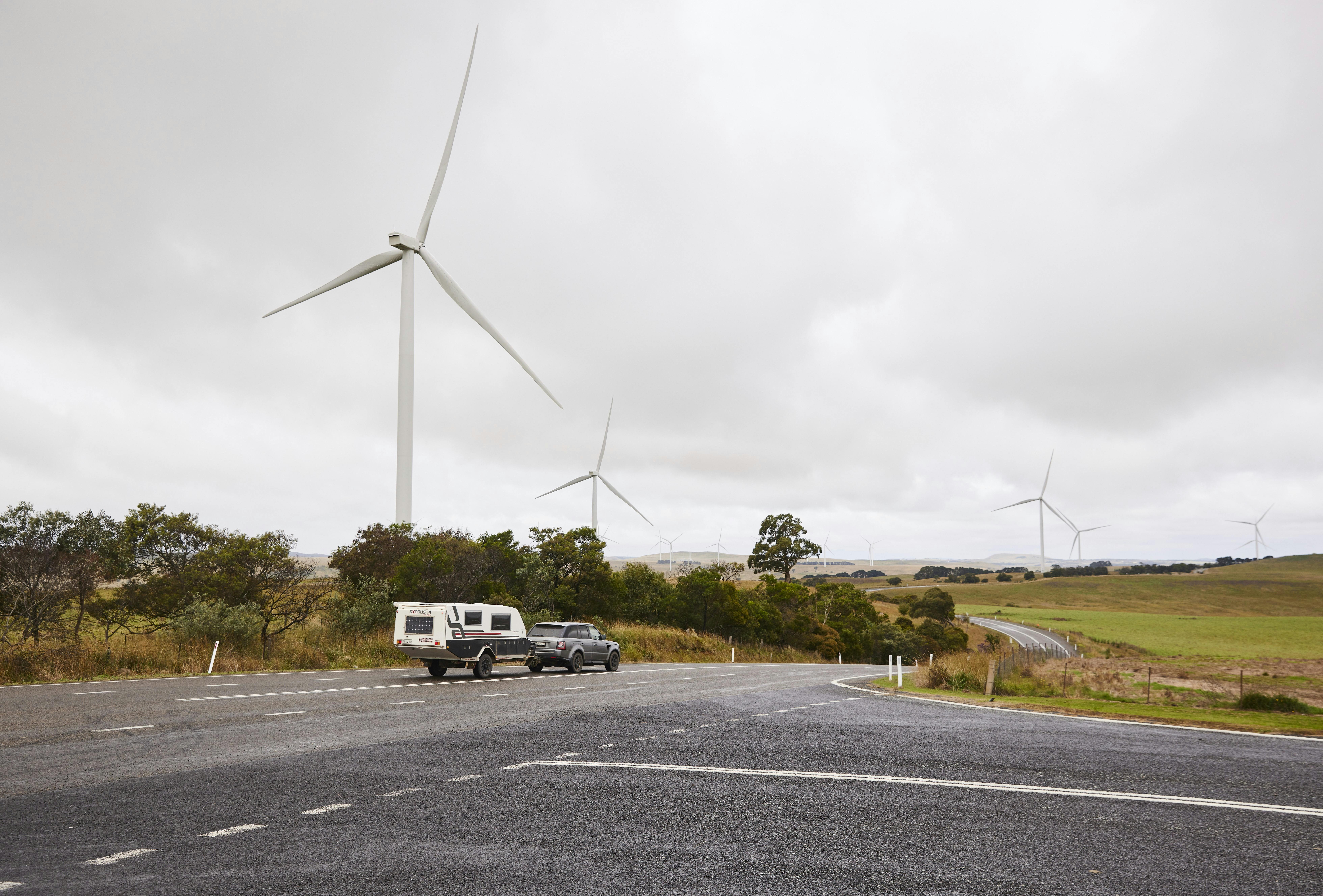 Crookwell Wind Farm with caravan and car driving through foreground