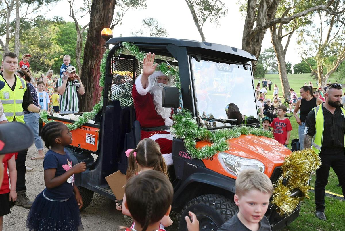 Santa arrives at the carols in an all terrain vehicle