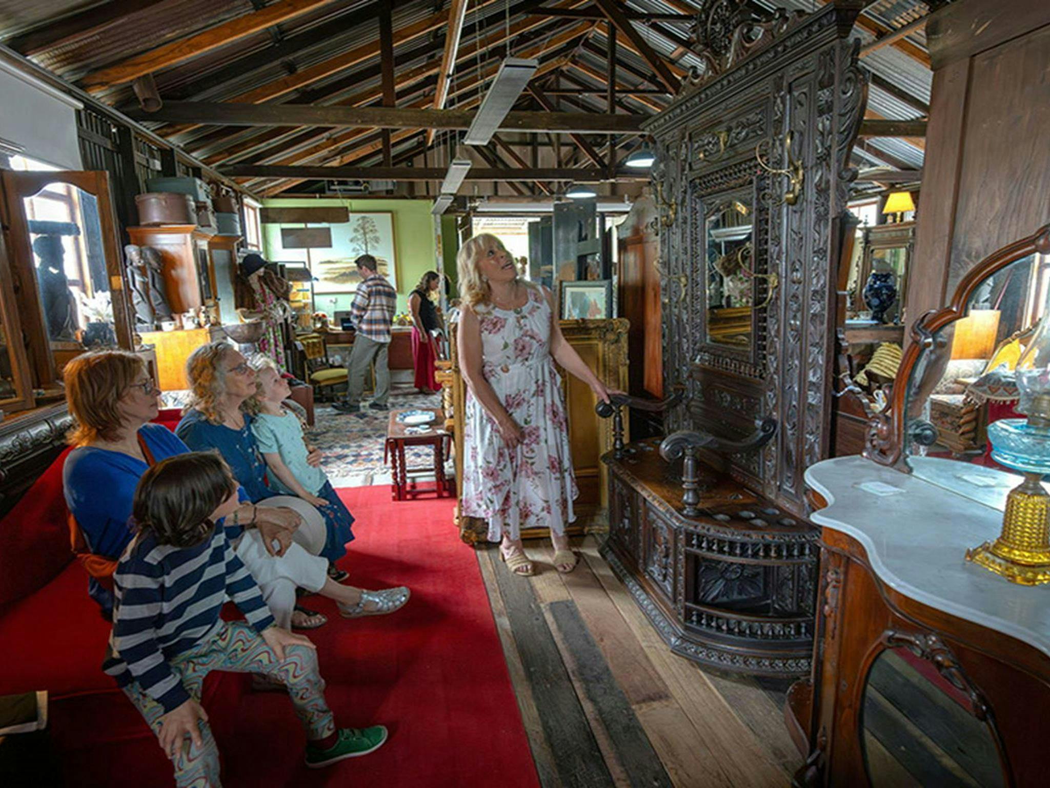 People admiring a large antique mirror inside Gold Rush Antiques in the old Corneys Garage. Credit: