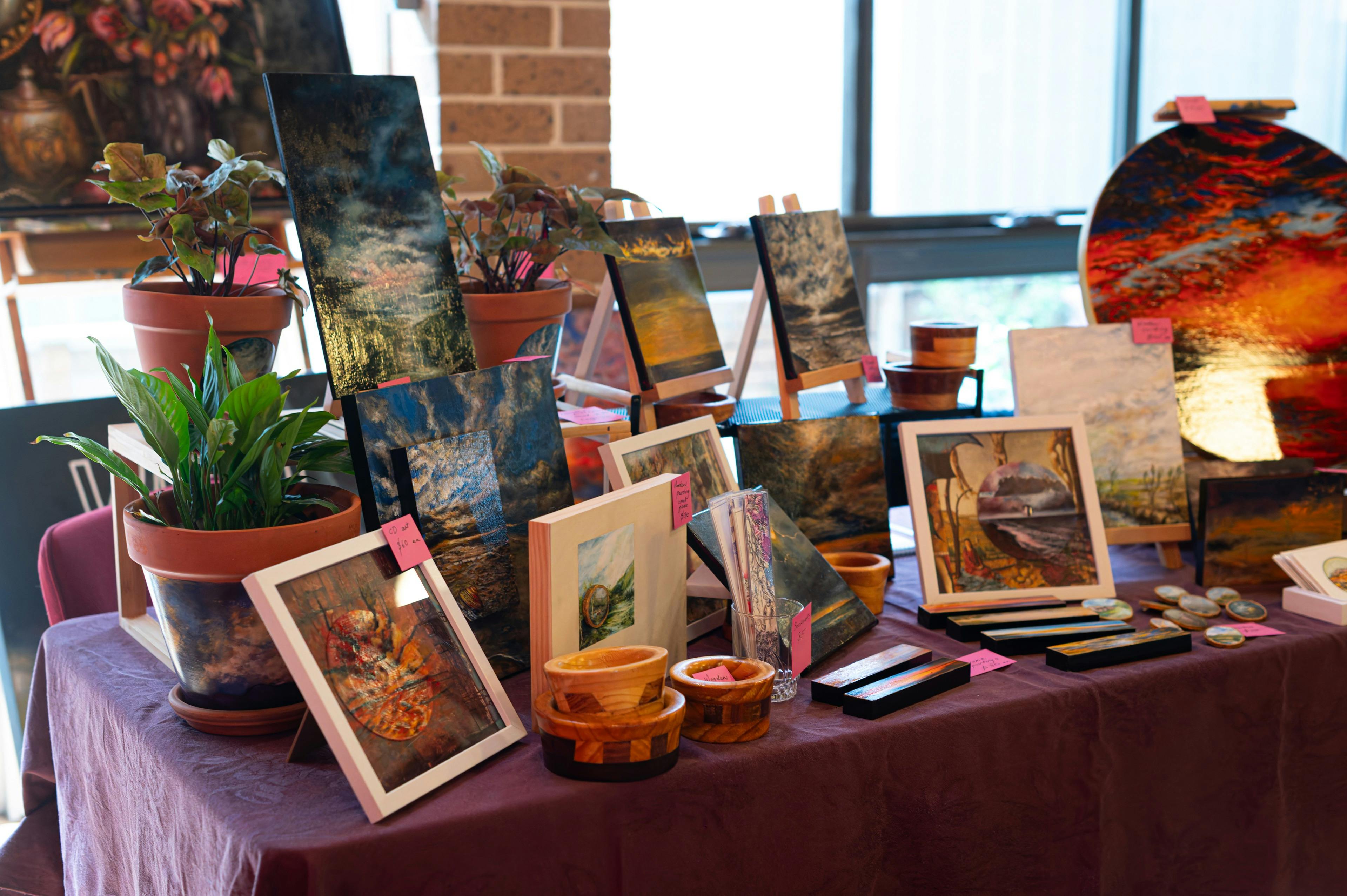 A display of artworks depicting landscapes arranged on a table.