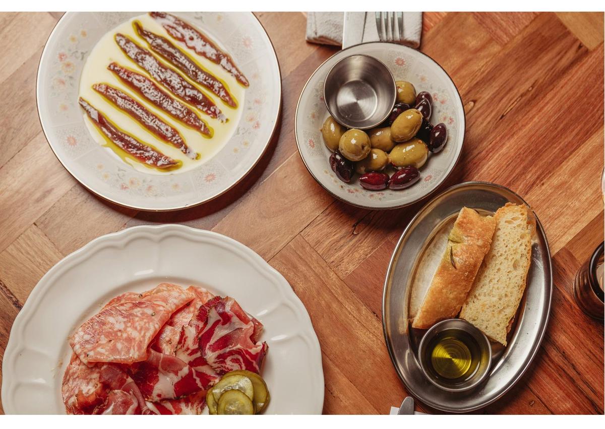 Plates of Anchovies, olives, sliced meats and focaccia