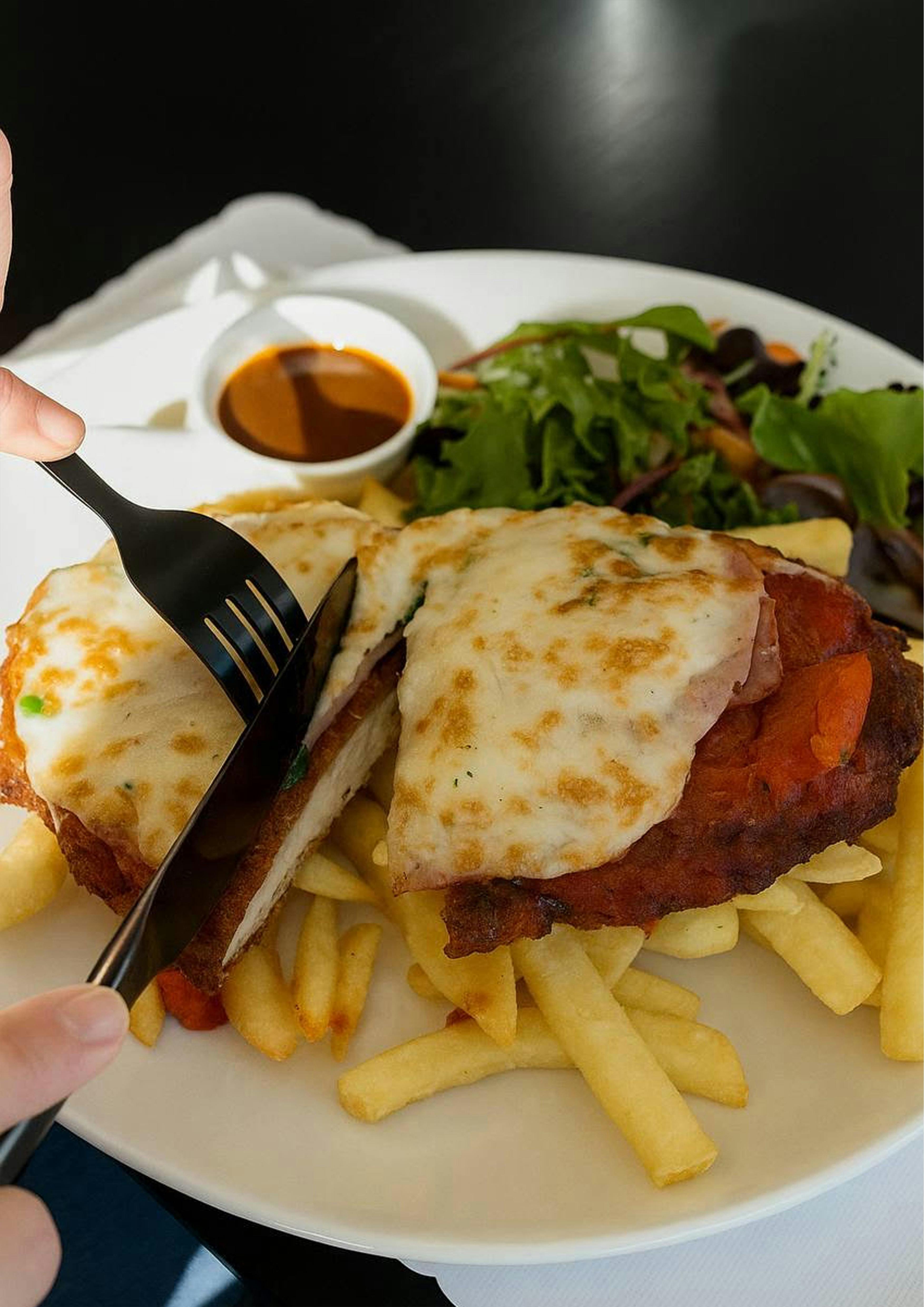Classic Esteria Chicken Schnitzel served with fries and salad.