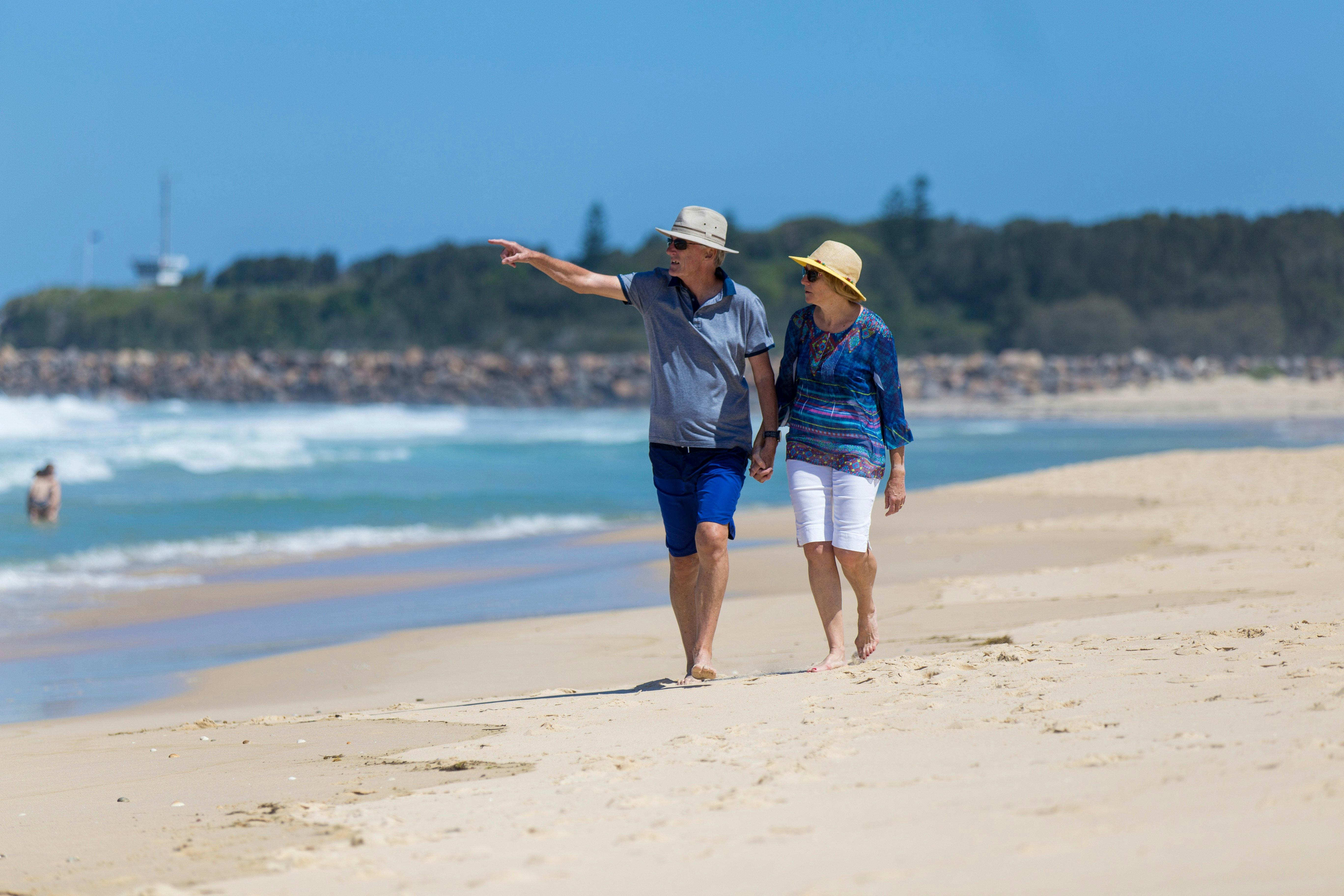Couple walking along Blacksmiths Beach