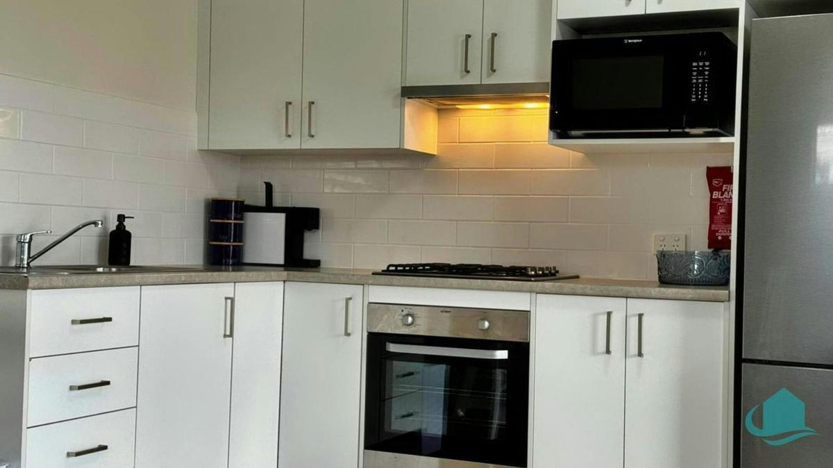Kitchenette with full sized fridge, microwave, oven and cooktop