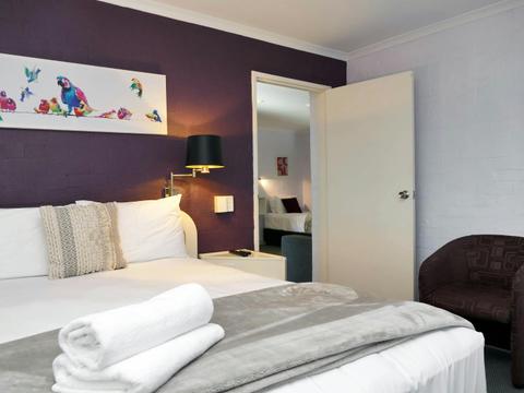 Premium queen bed room with corner spa. Adjoins family room with two single beds, desk, sofa & table