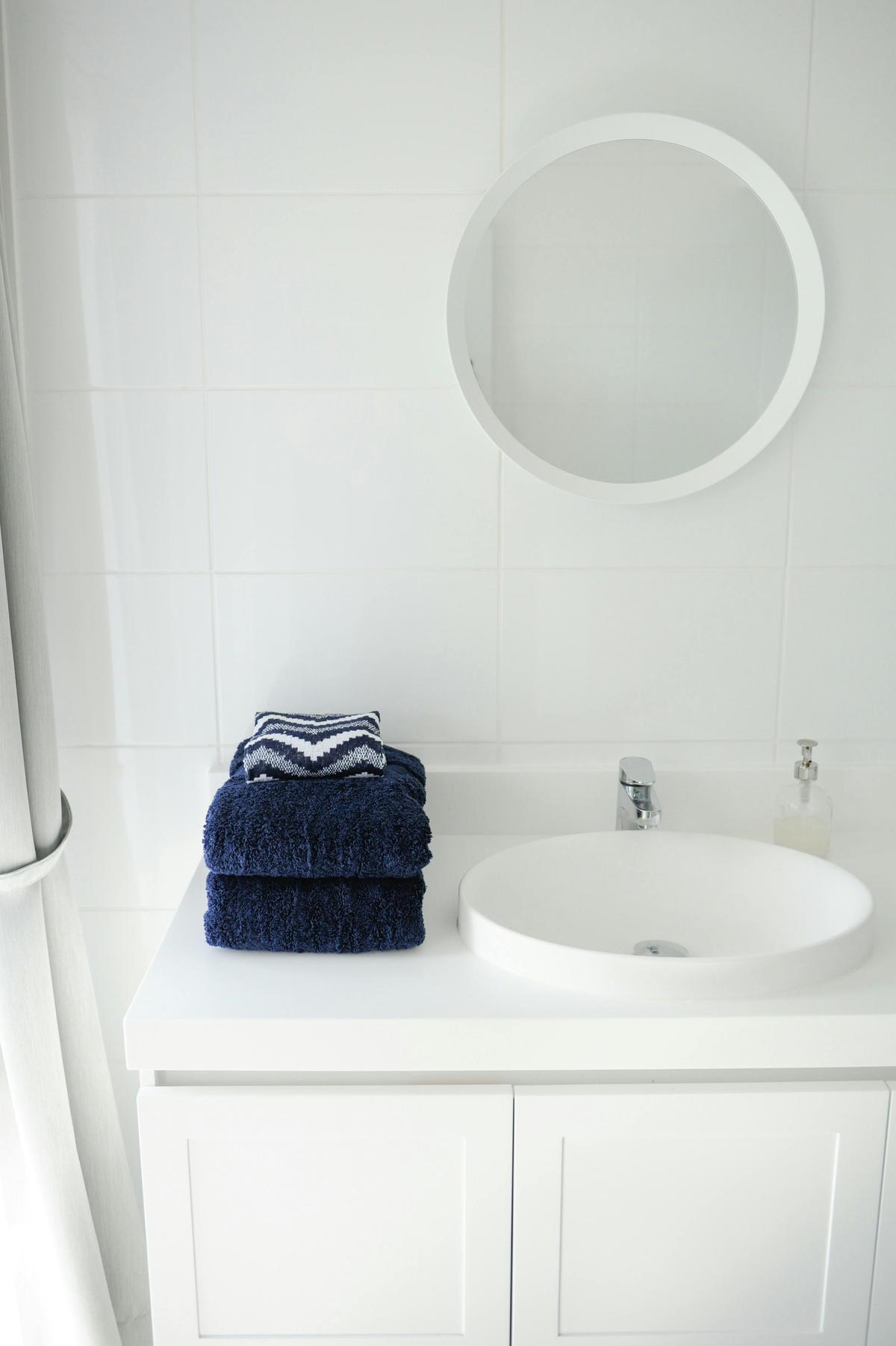 Main bathroom with shower over deep bath tub and washer/dryer.