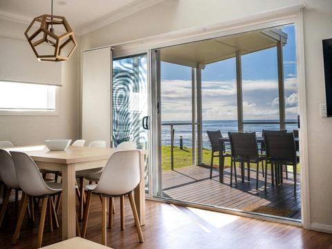 Dining and living area looking out towards large deck and views of ocean