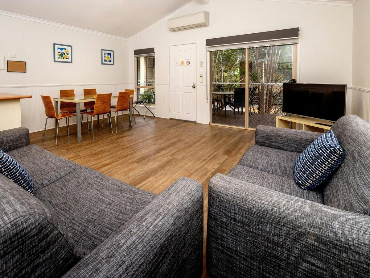 Open plan living area with two sofas, dining table seating 6