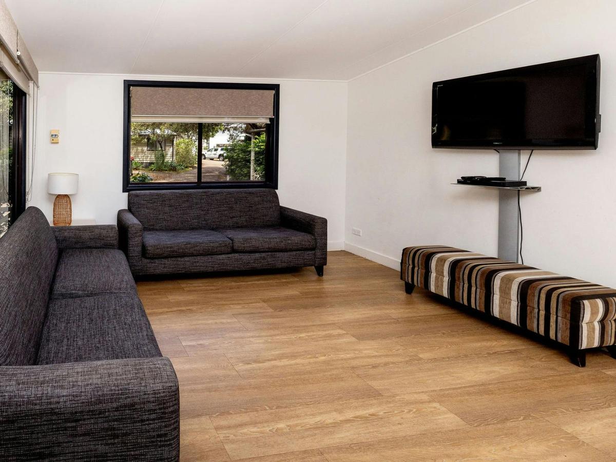 Lounge are with two grey sofas and a wall mounted tv