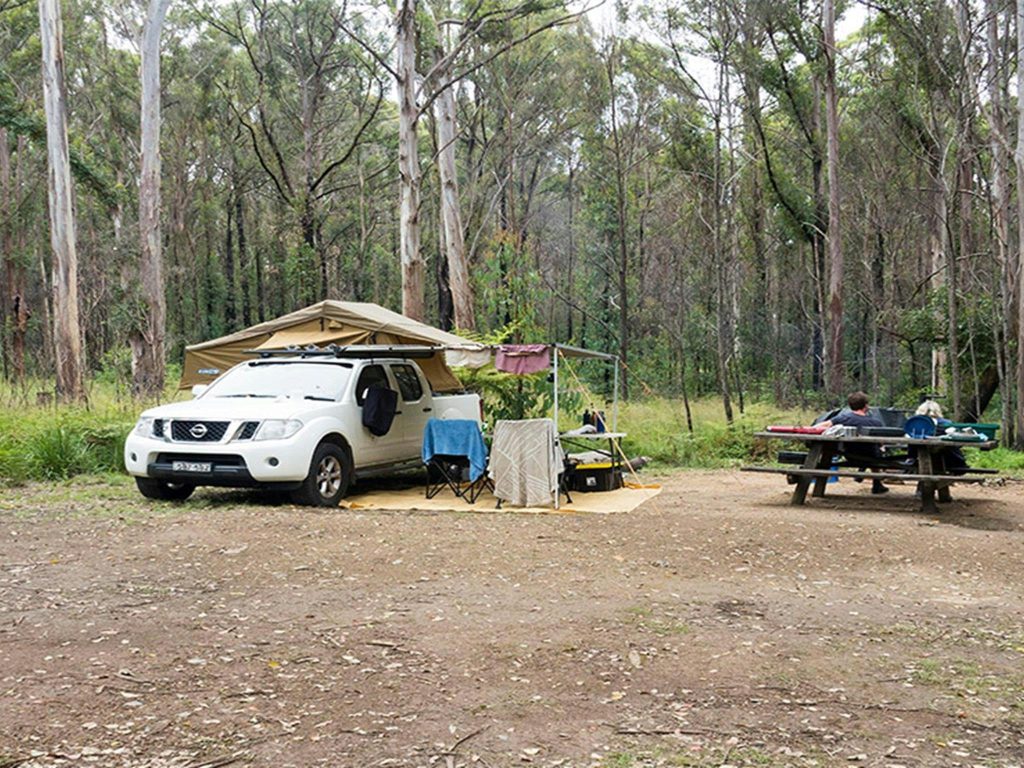 A camper trailer and picnic bench at Boundary Falls campground. Credit: Leah Pippos &copy; DCCEEW