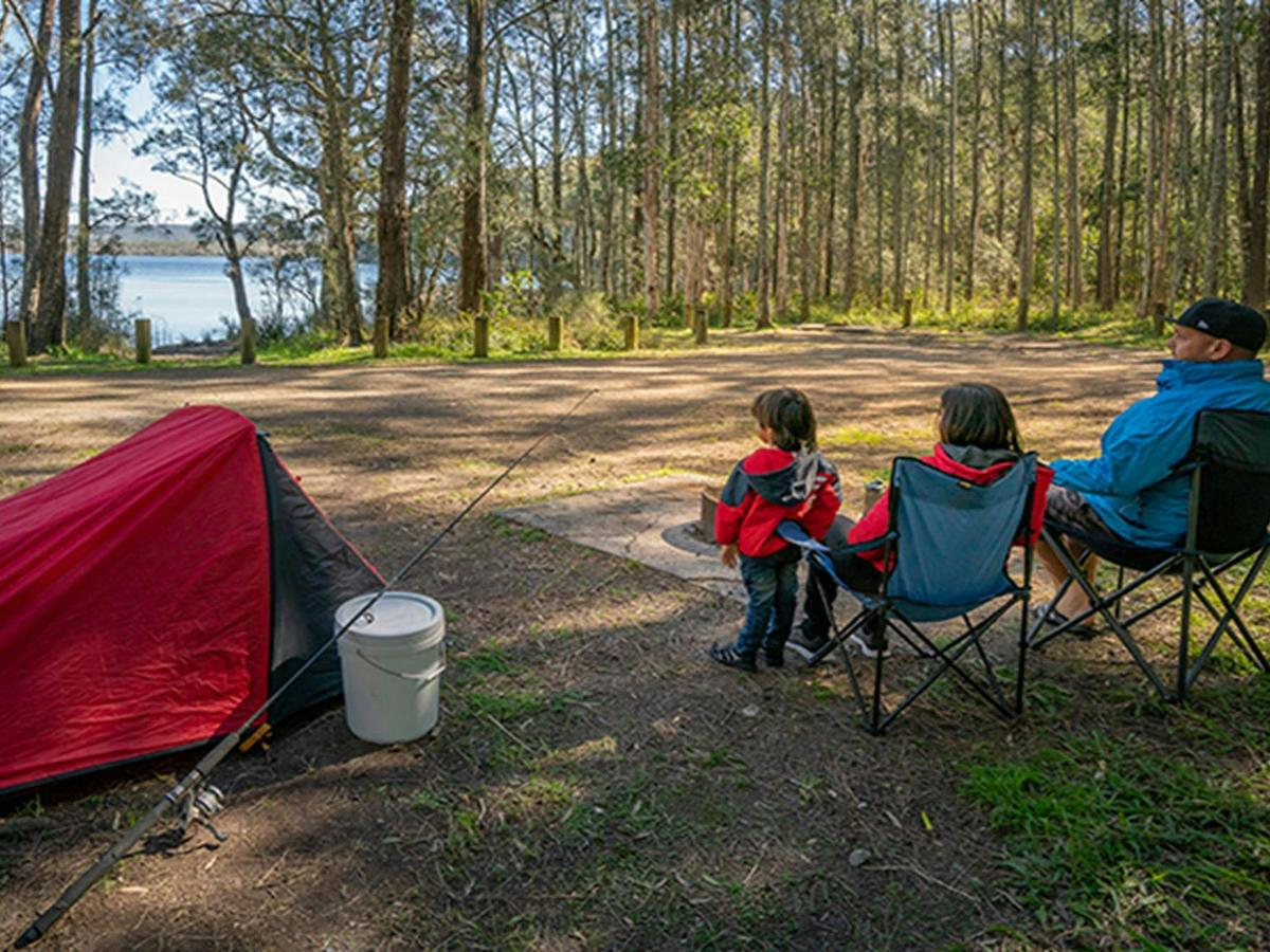 Family watching the lake by their tent at Bungarie Bay campground. Photo: John Spencer/OEH