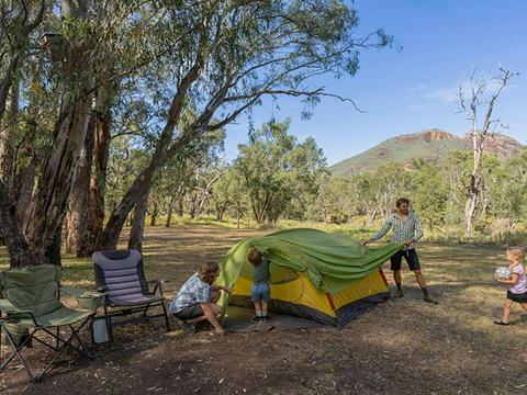 A family setting up their tent at Camp Blackman. Credit: John Spencer &copy; DCCEEW