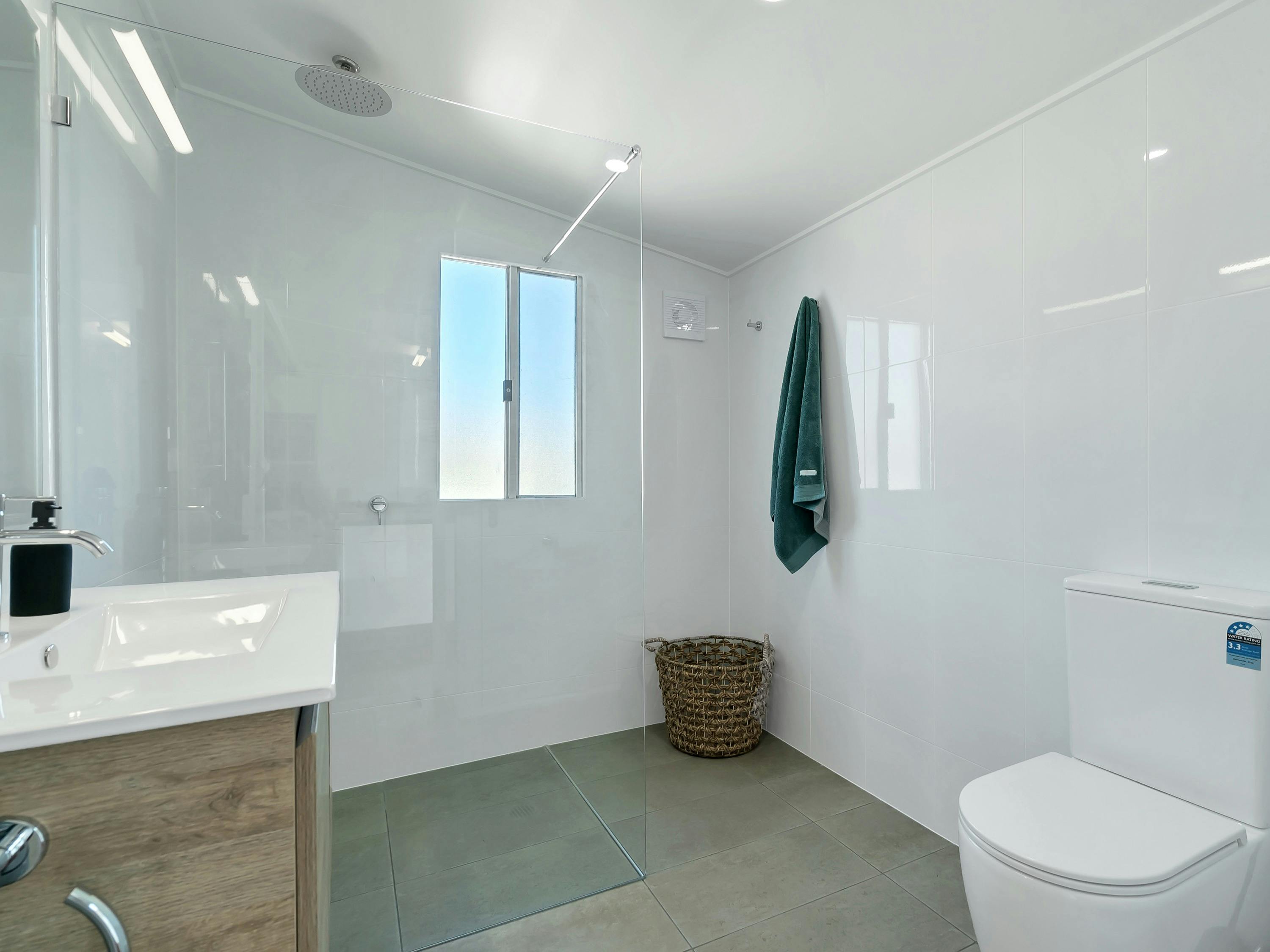 A roomy, modern bathroom with an oversized shower, perfect for unwinding after a day at the beach.