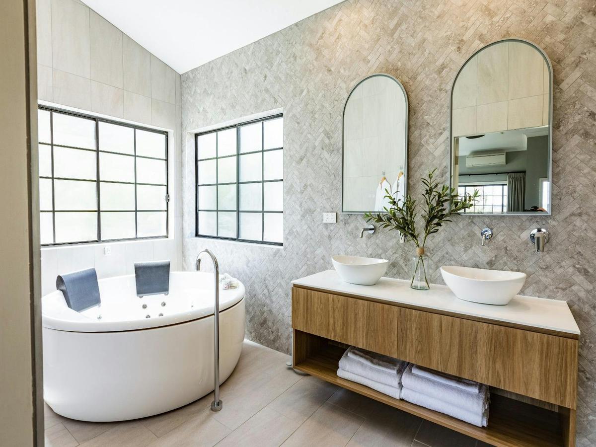 Elegant bathroom interior showcasing a large tub and dual sinks, emphasizing a modern and luxurious