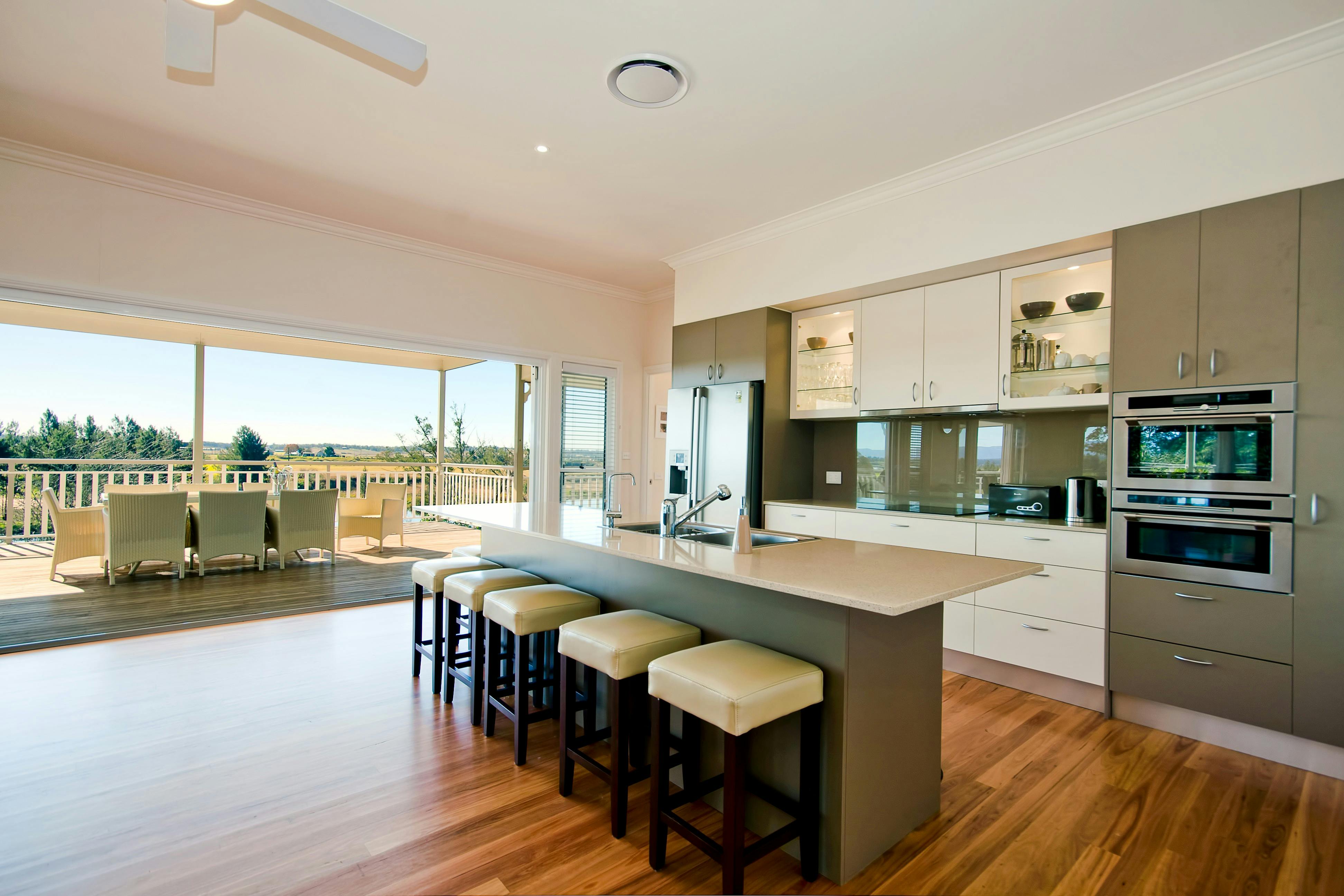 Gourmet kitchen with island bench leads out to the verandah
