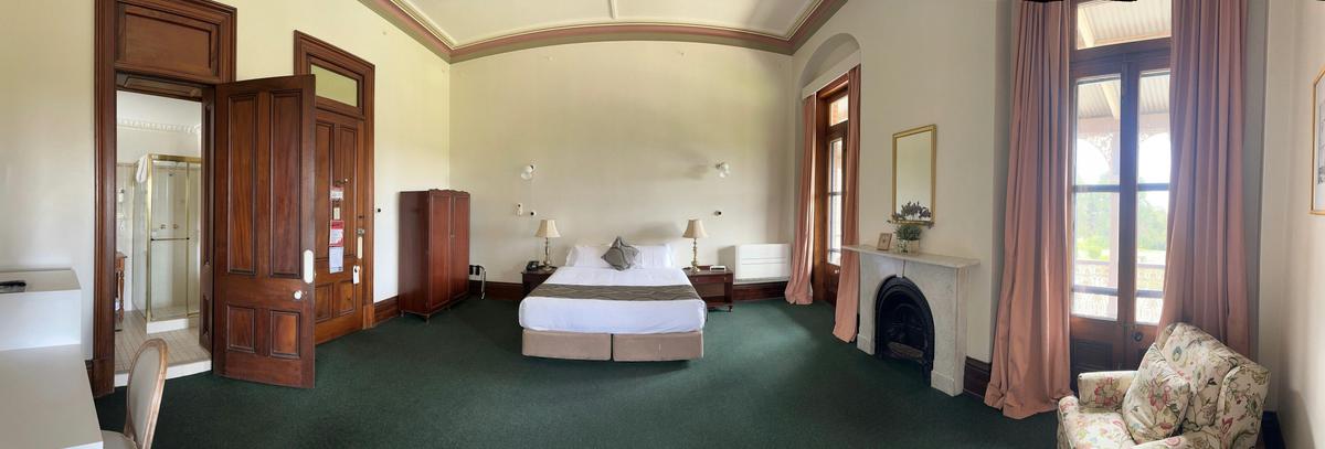 A wide shot of the large room, with the king bed in the centre.