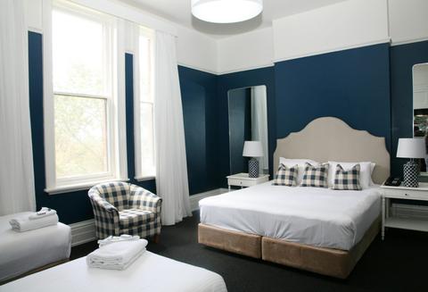 A shot showing a king bed and the corner of a single bed.