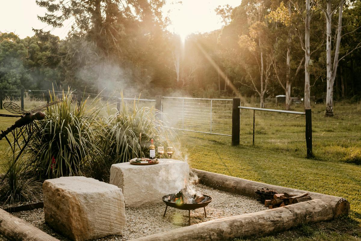 Unwind by the firepit with wine, native plants, and sunset views at Contained in Nimbin.