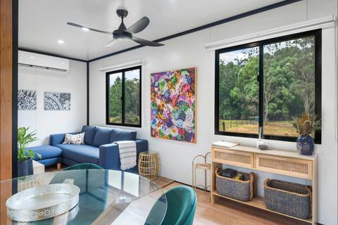 Internal image of lounge, dining, entry way and artwork, overlooking the paddocks of the farm