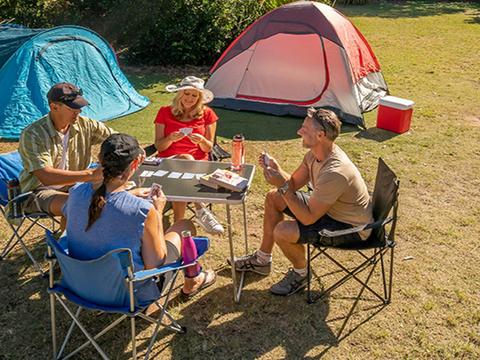 A group of friends playing cards next to their tents. Photo: John Spencer/DPIE