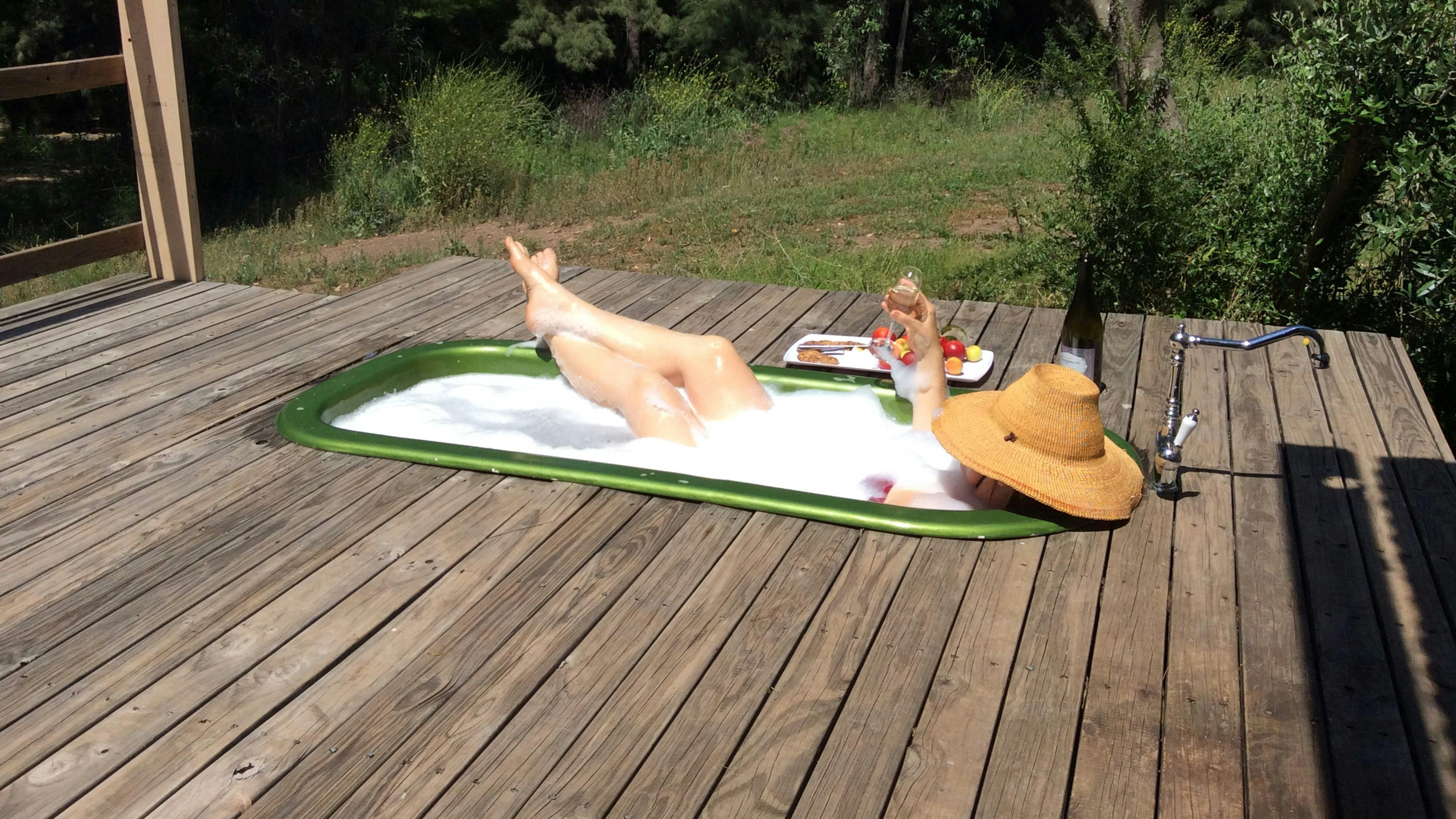 Guests enjoying a hot bath while drinking Champagne , listening to the bird life and creek!!