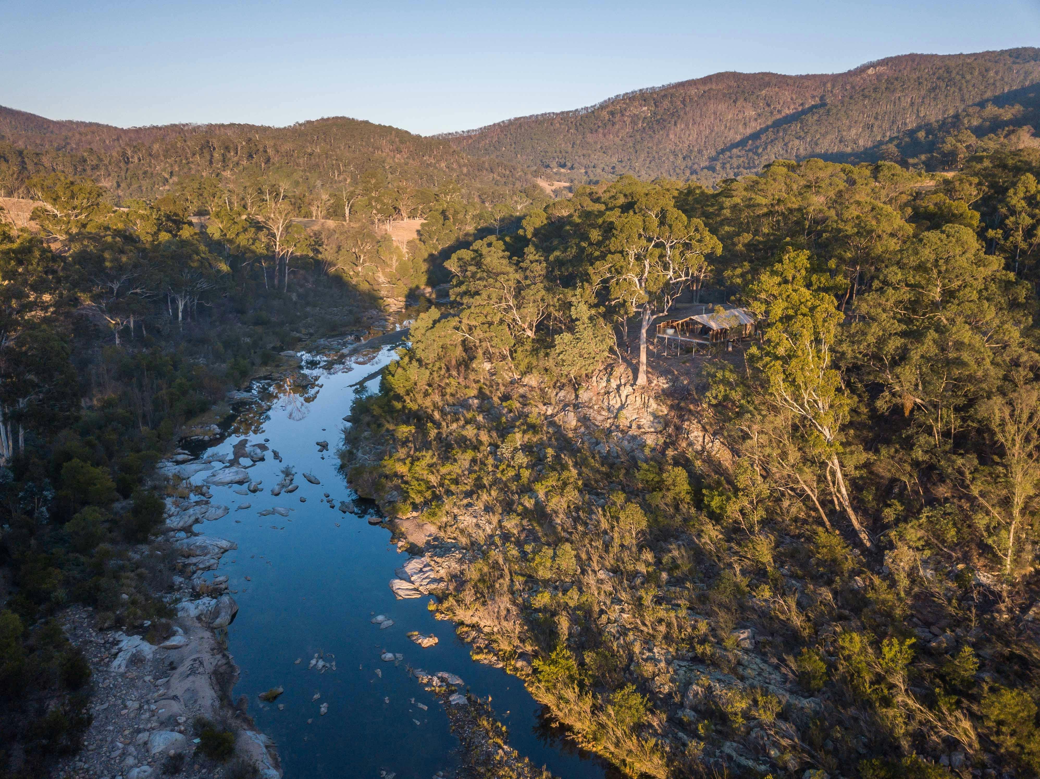 Safari tent and surrounding landscape including river and farmland