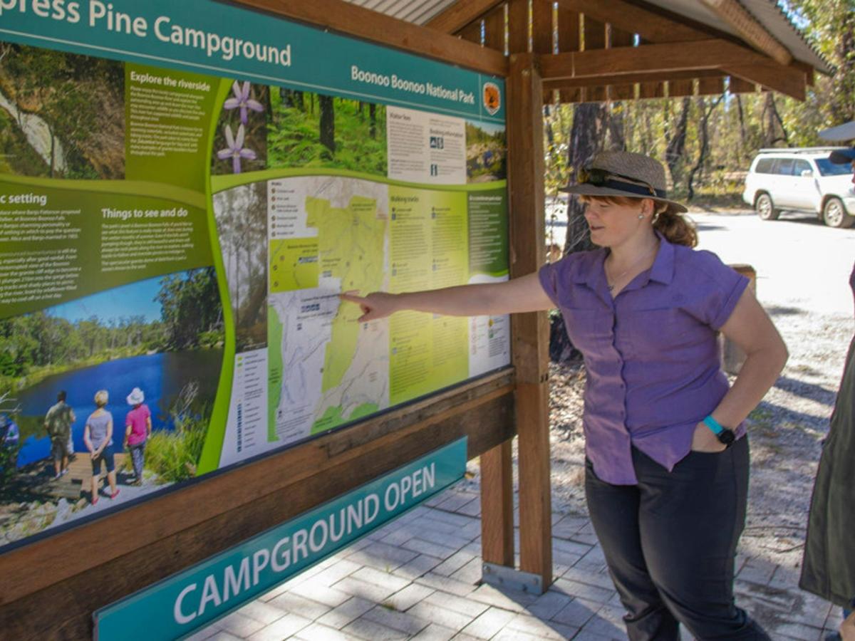 Visitors reading the Cypress Pine campground sign. Credit: Joshua J Smith &copy DPIE