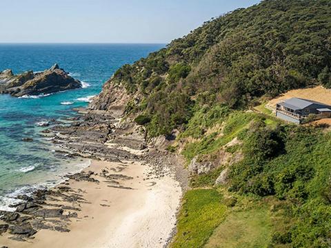Aerial view of Davies Cottage, set on a hill above Boat Beach and Sugarloaf Bay in Myall Lakes