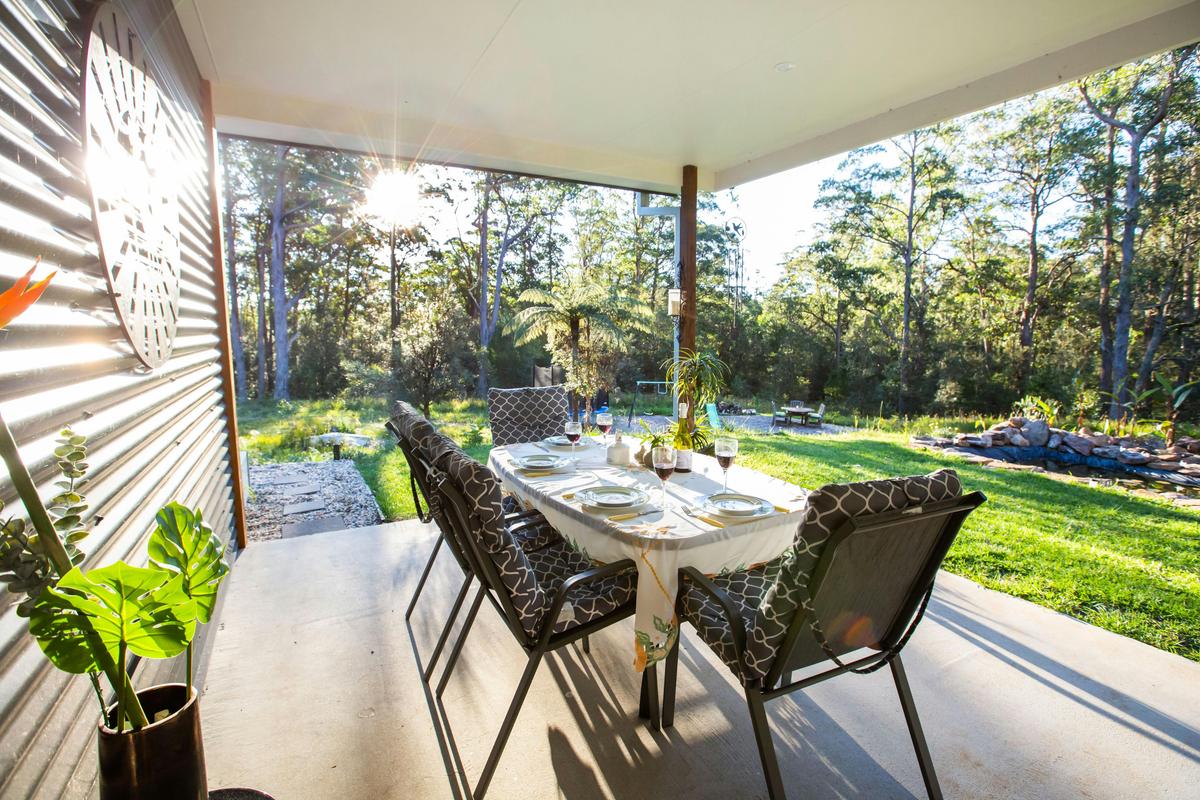 Alfresco dining on deck with views of the dam and bush