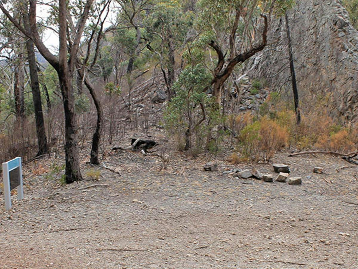 Camping area at Danu camp, set in rugged landscape of bushes, trees and rock formations. Photo: