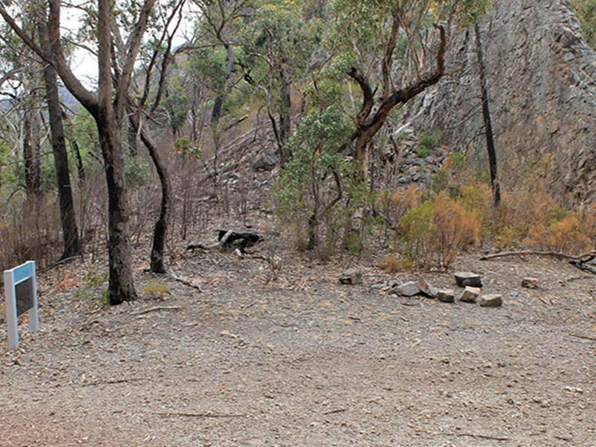 Camping area at Danu camp, set in rugged landscape of bushes, trees and rock formations. Photo: